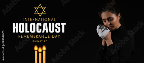 Young woman with armband praying on black background. Banner for International Holocaust Remembrance Day photo