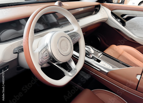 Red luxury modern car Interior. Steering wheel, shift lever and dashboard. Detail of modern car interior. Automatic gear stick. Part of leather seats with stitching © Aleksei