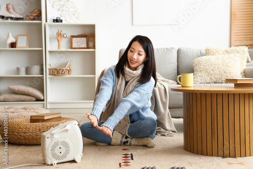 Young Asian woman warming n...