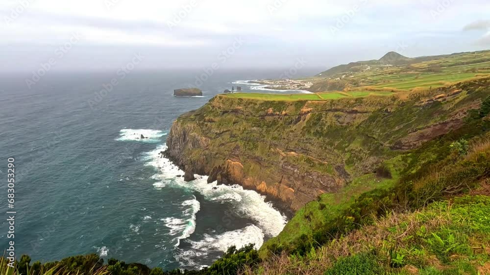 Views from a viewpoint of the a green cliff and the sea, rocks and waves in Azores island Views from a viewpoint of the a green cliff and the sea, rocks and waves in Azores island