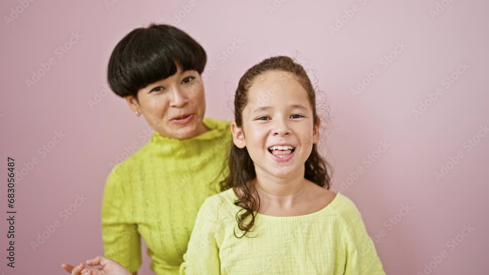 Mother joyfully video calls confident daughter, both sharing happiness and laughter over isolated pink background. lovely family moment of togetherness and love. Mother joyfully video calls confident daughter, both sharing happiness and laughter over isolated pink background. lovely family moment of togetherness and love.