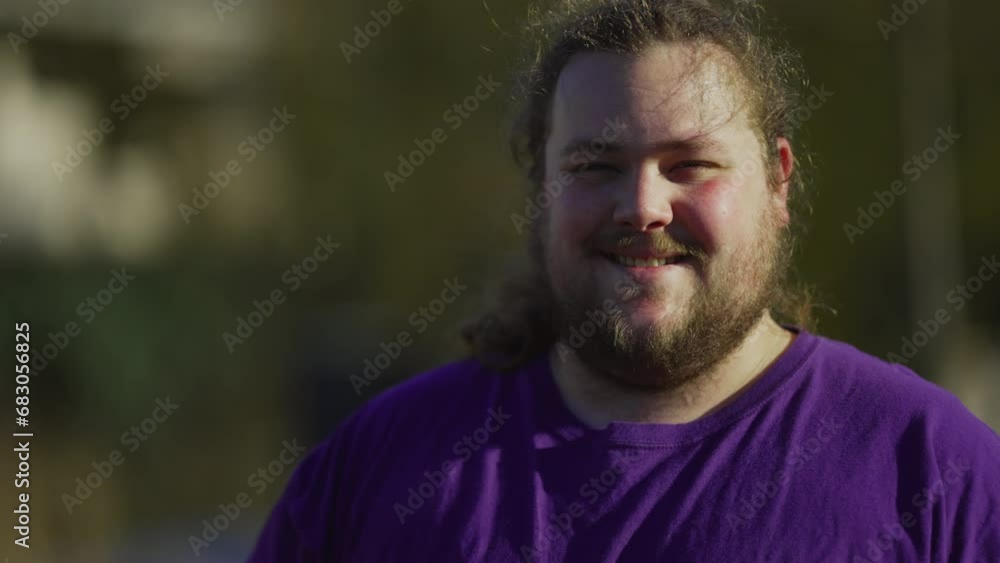 Portrait of a happy casual young 20s man standing outside looking at camera. Millennial caucasian male chubby person Portrait of a happy casual young 20s man standing outside looking at camera. Millennial caucasian male chubby person