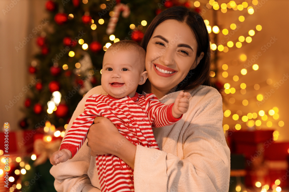 Young mother and her little baby at home on Christmas eve Young mother and her little baby at home on Christmas eve