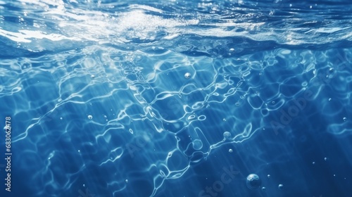 Black water with ripples on the surface. Defocus blurred transparent blue colored clear calm water surface texture with splashes and bubbles. Water waves with shining pattern texture background