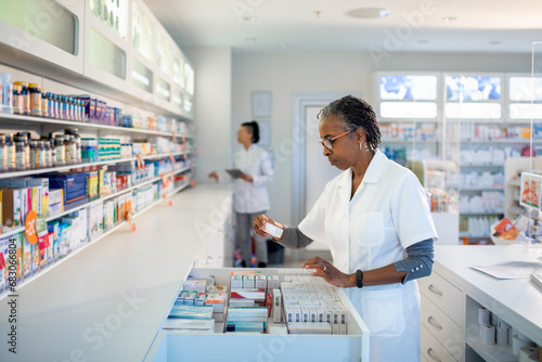 Pharmacist Examining Medication in Pharmacy photo