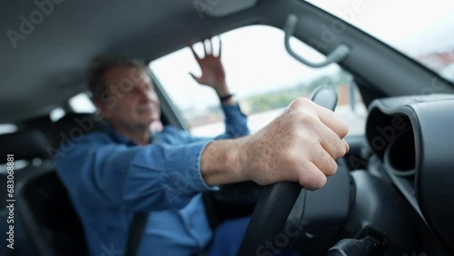 Closeup of senior person hands on steering wheel driving car. Older man driving a moving vehicle commuting from work photo