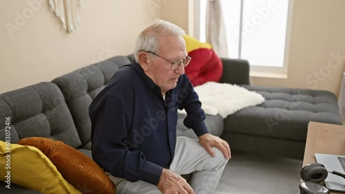 Senior man sitting on sofa standing up and walk away at home