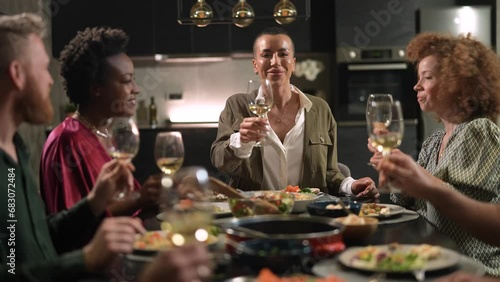 Young woman propose a toast during home dinner with friends