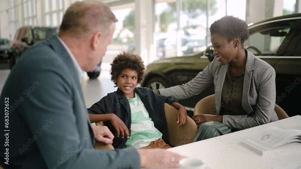 Family signing contract and getting keys for new car at the dealership Family signing contract and getting keys for new car at the dealership