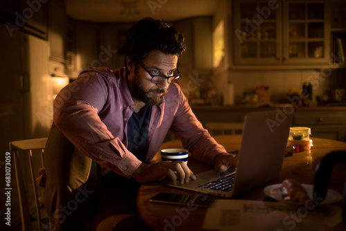 Young man online banking from home