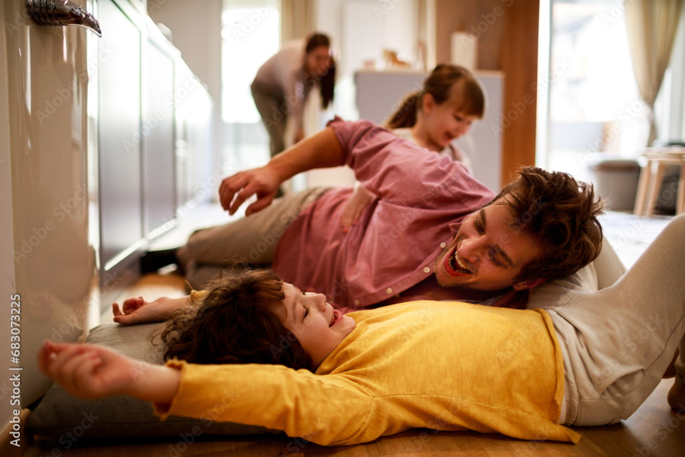 Happy young dad having fun with his kids on the floor at home Happy young dad having fun with his kids on the floor at home
