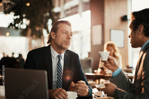 Two businessman sitting in cafe talking