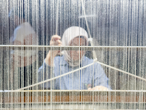 Traditional textile manufacture Weaving thread for the textile industry.extract,Woven silk,using cotton and silk string stretch and woven by using mechanic wooden machine to weave,