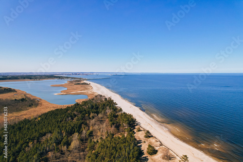 Aerial view drone of river goes into the sea. Delta of Vistula river goes in Baltic Sea in Sobieszewo Gdansk Poland. Forest and small village around river photo
