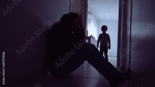 Child hugging mother suffering at home floor. Little boy silhouette consoling parent during depression. Single mother with kid photo