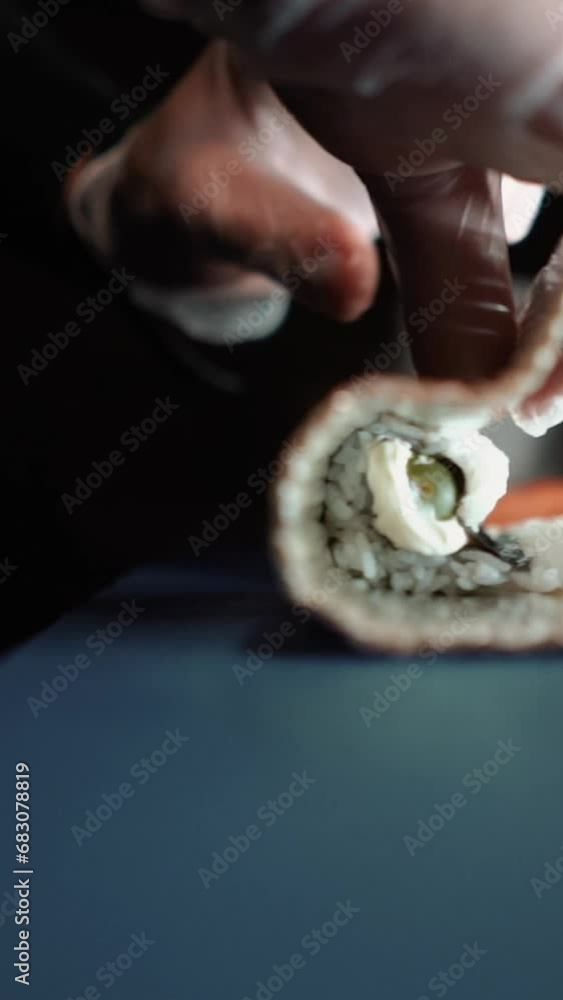 Master sushi maker makes sushi rolls from nori rice and red fish, the process of preparing Japanese food close-up, orange salmon trout fish Master sushi maker makes sushi rolls from nori rice and red fish, the process of preparing Japanese food close-up, orange salmon trout fish