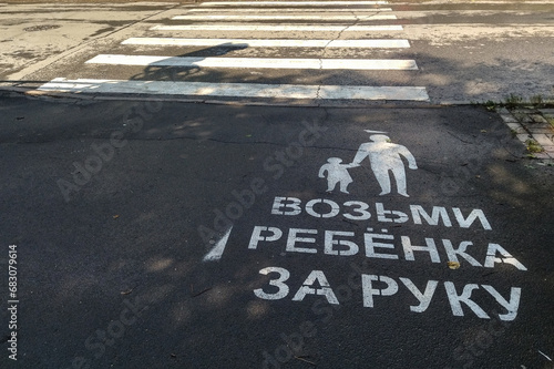 On the asphalt in front of the pedestrian crossing there is an inscription - Take the child by the hand - to attract the attention of pedestrians in order to reduce traffic accidents.