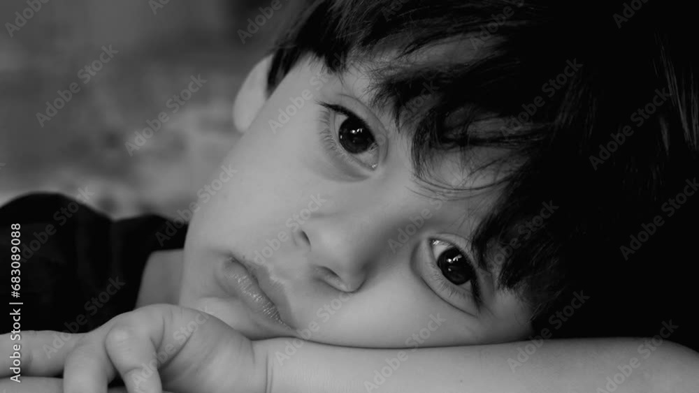 Sad depressed small boy close-up face in dramatic black and white. Contemplative child gazing in the distance, lost in thought Sad depressed small boy close-up face in dramatic black and white. Contemplative child gazing in the distance, lost in thought