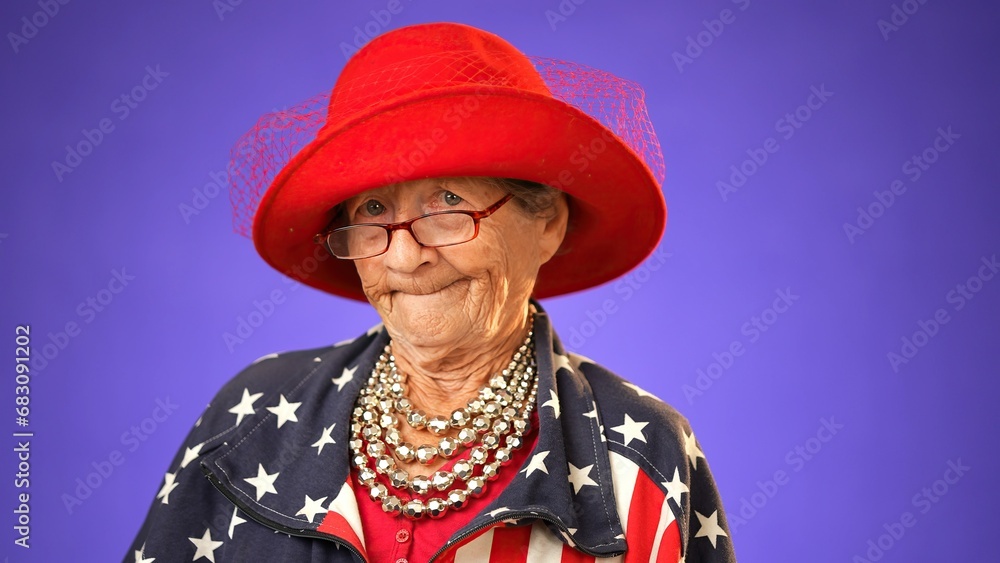 Confident senior elderly woman 80s wears American flag jacket pointing fingers on herself showing thumb up like gesture motivating encourage isolated on purple background in studio Confident senior elderly woman 80s wears American flag jacket pointing fingers on herself showing thumb up like gesture motivating encourage isolated on purple background in studio
