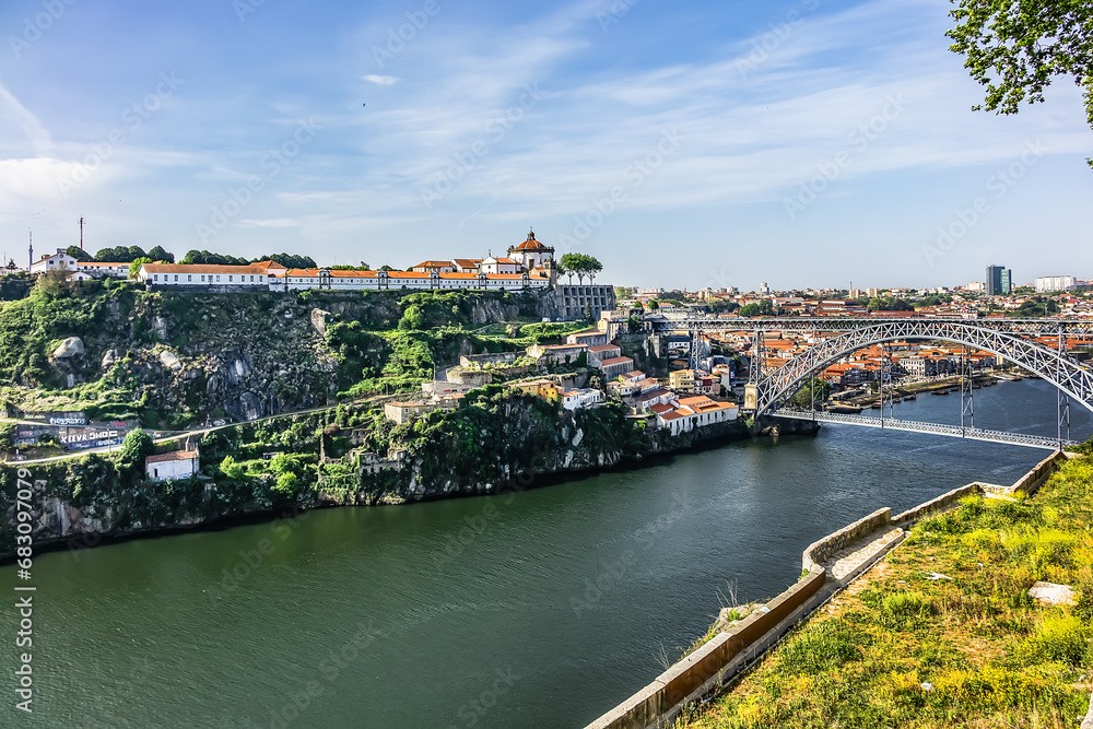 View of the iconic Dom Luis I - double-deck metal arch bridge (172 meters, 1886) crossing the Douro River and the historical Ribeira and Se District in the city of Porto, Portugal. 