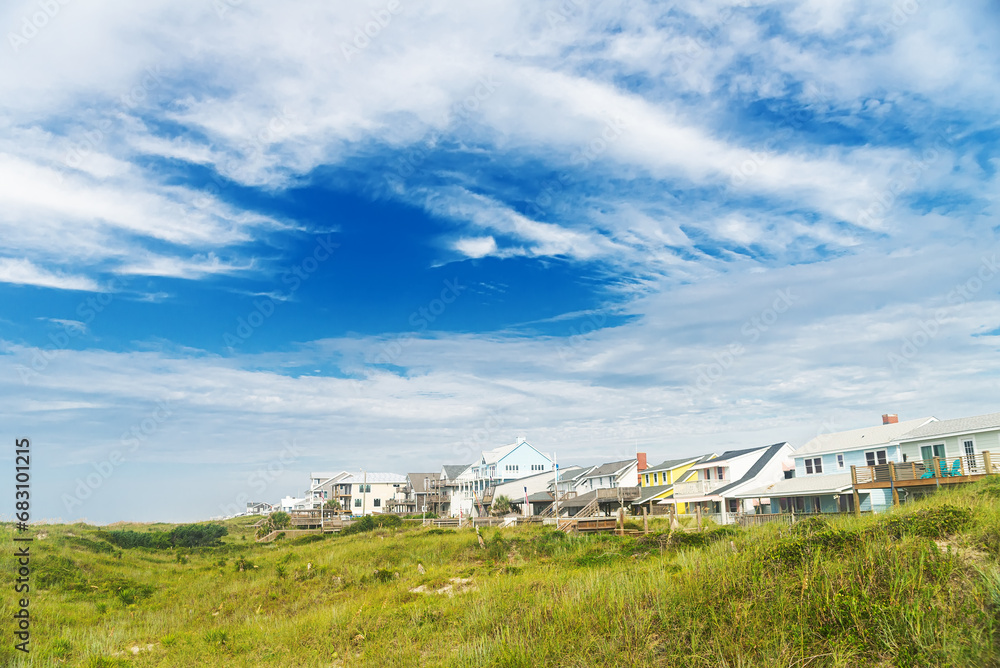 Rows of houses on the shores of the Atlantic Ocean. Tall grass and blue sky of North Carolina. Rows of houses on the shores of the Atlantic Ocean. Tall grass and blue sky of North Carolina.