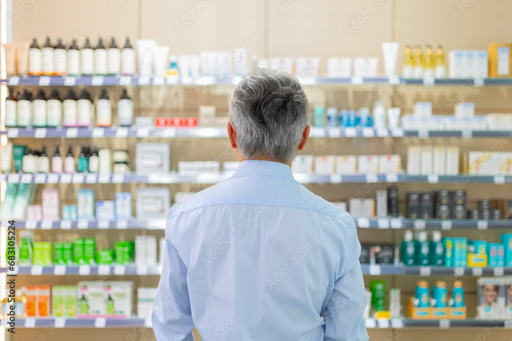Anonymous man standing by shelves in drugstore Anonymous man standing by shelves in drugstore