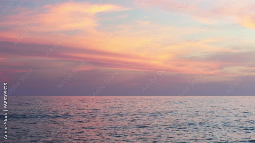 Soft pink hues streak the sky at dusk over the Atlantic Ocean in Algarve, Portugal Soft pink hues streak the sky at dusk over the Atlantic Ocean in Algarve, Portugal