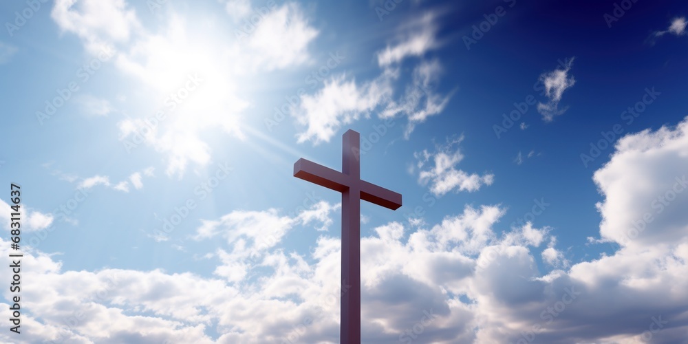 A sunlit sky behind a cross atop a stone hill.
