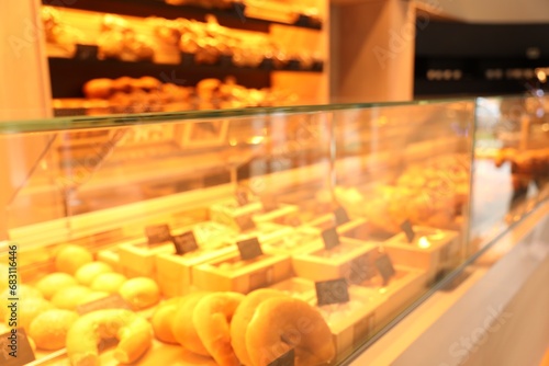 Blurred view of fresh pastries on counter in bakery store