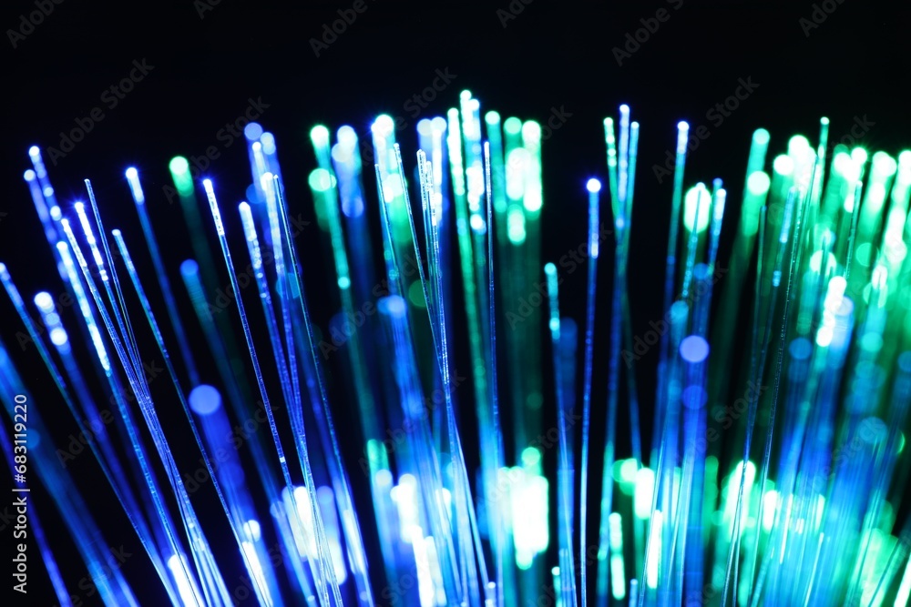Optical fiber strands transmitting different color lights on black background, closeup Optical fiber strands transmitting different color lights on black background, closeup