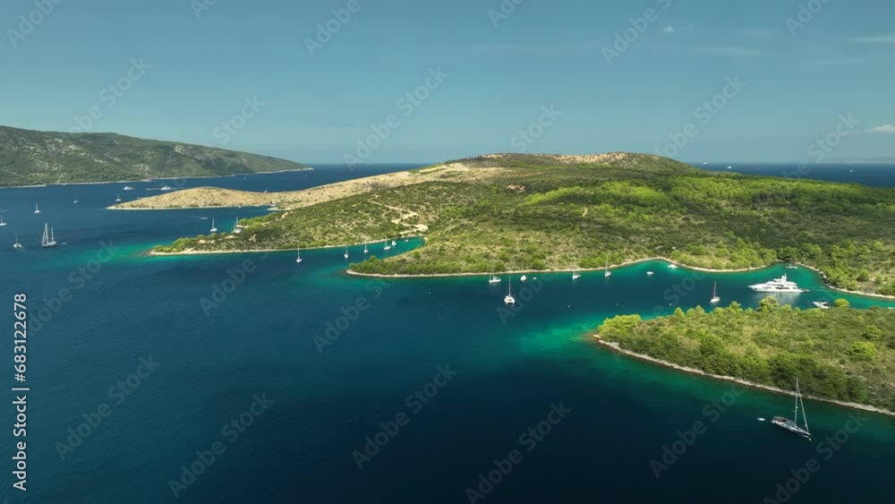 Luxury yachts anchored in the clear bays at Hvar island. Backwards drone aerial shot Luxury yachts anchored in the clear bays at Hvar island. Backwards drone aerial shot