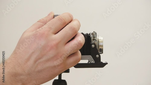 Hand on vintage photo camera lens sets parameters, side view photo