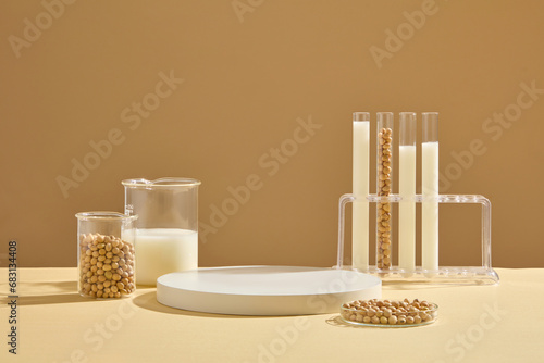 A petri dish, beaker and test tubes on the rack containing soybeans and milk displayed with a podium. Blank space on the podium to display product extracted from Soybean (Glycine max)