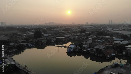 Aerial Drone Footage Sub Urban Village Sunrise Silhouette with a Lake Pond at Kapuk, Cengkareng, West Jakarta, Indonesia photo