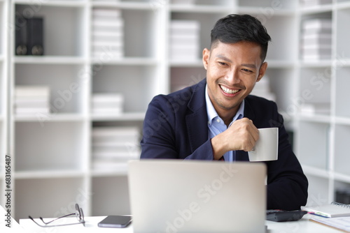 Businessman working with laptop computer in office and drinking coffee in the morning.