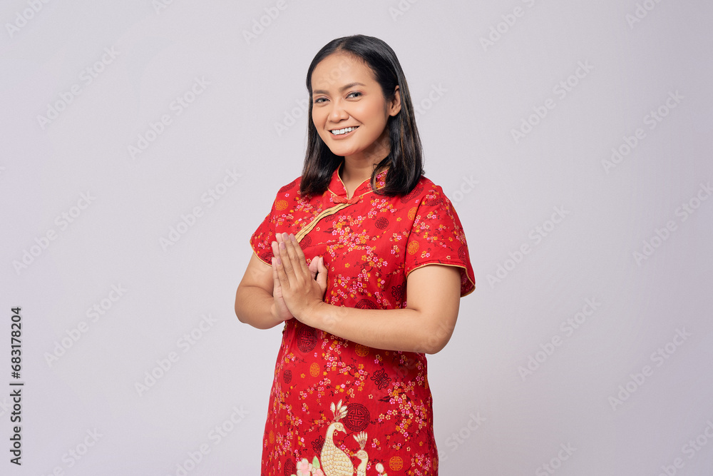 Happy Chinese New Year. Young Asian women wearing traditional cheongsam qipao dress and greeting with hand isolated on white background Happy Chinese New Year. Young Asian women wearing traditional cheongsam qipao dress and greeting with hand isolated on white background