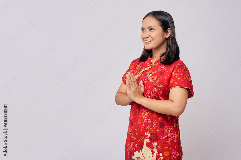 Happy Chinese New Year. Young Asian women wearing traditional cheongsam qipao dress and greeting with hand isolated on white background Happy Chinese New Year. Young Asian women wearing traditional cheongsam qipao dress and greeting with hand isolated on white background