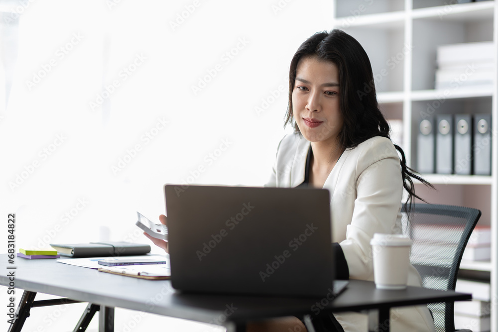 Attractive asian businesswoman secretary working with laptop and paperwork in office. Attractive asian businesswoman secretary working with laptop and paperwork in office.