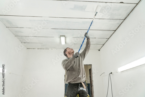 Skilled Craftsman Painting a Room in Fresh Overalls with Precision and Care.