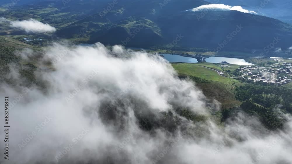 flying through the clouds and atmospheric mist in the early morning with sun rays beaming through the sky and lakes in the mountainous background in Colorado AERIAL DOLLY flying through the clouds and atmospheric mist in the early morning with sun rays beaming through the sky and lakes in the mountainous background in Colorado AERIAL DOLLY
