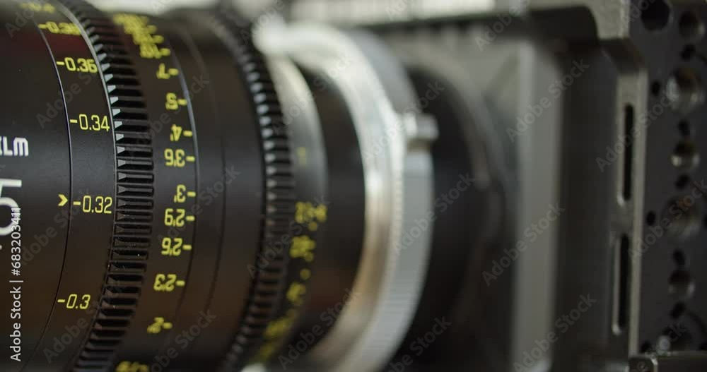 Medium close up shot of a cinema lens with moving focus barrel. Camera assistant pulling focus on the lens. Medium close up shot of a cinema lens with moving focus barrel. Camera assistant pulling focus on the lens.