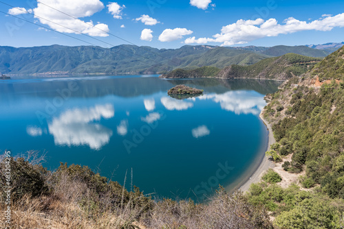 Blue sky and white clouds reflected on the surface of Lugu Lake photo