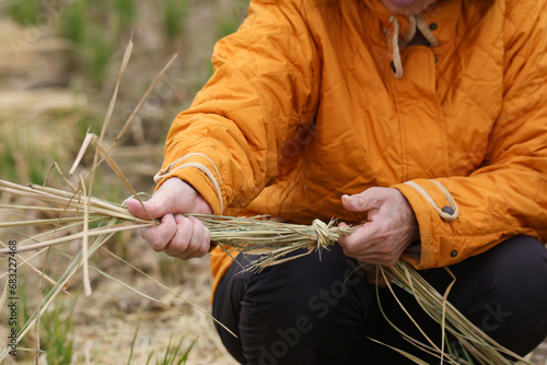 稲藁を結ぶ女性