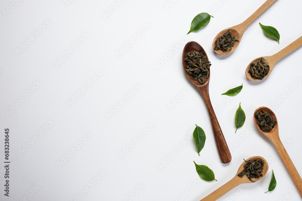 Dry green tea on a wooden spoons with a fresh gren leaves, isolated on white background. Top view, falt lay. Space for text, copy space. - obrazy, fototapety, plakaty 