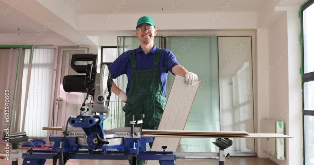 Laminate laying specialist with laminate cutting machine with disc. Renovation in offices and apartments and laying flooring Laminate laying specialist with laminate cutting machine with disc. Renovation in offices and apartments and laying flooring