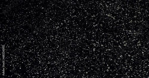 Animated realistic detailed snow flakes slowly falling densely against black background. photo
