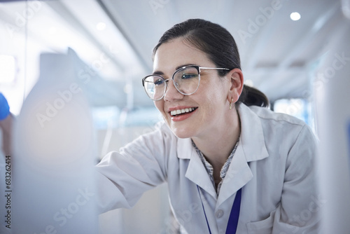 Woman, medical scientist and in lab happy for vial discovery or research future vaccine, review or technology. Female person, glasses and study breakthrough for antibiotic, help job or innovation