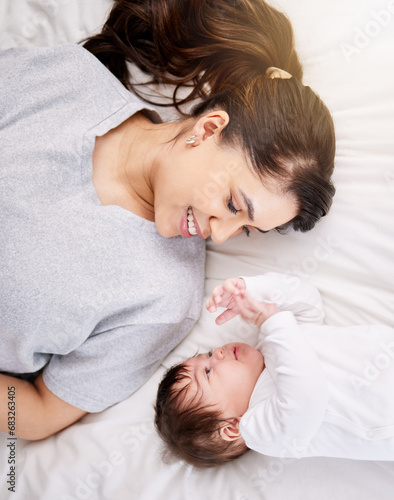 Mother, baby and bed with love and care or security with smile or bond in comfort and peace. A woman or mom and infant child in a bedroom for safety in a family home for growth, above and connection
