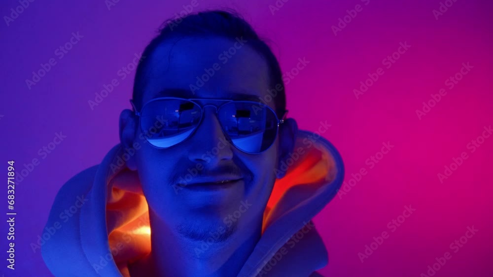 Neon light studio close-up portrait of a male model with a mustache and beard wearing sunglasses Neon light studio close-up portrait of a male model with a mustache and beard wearing sunglasses