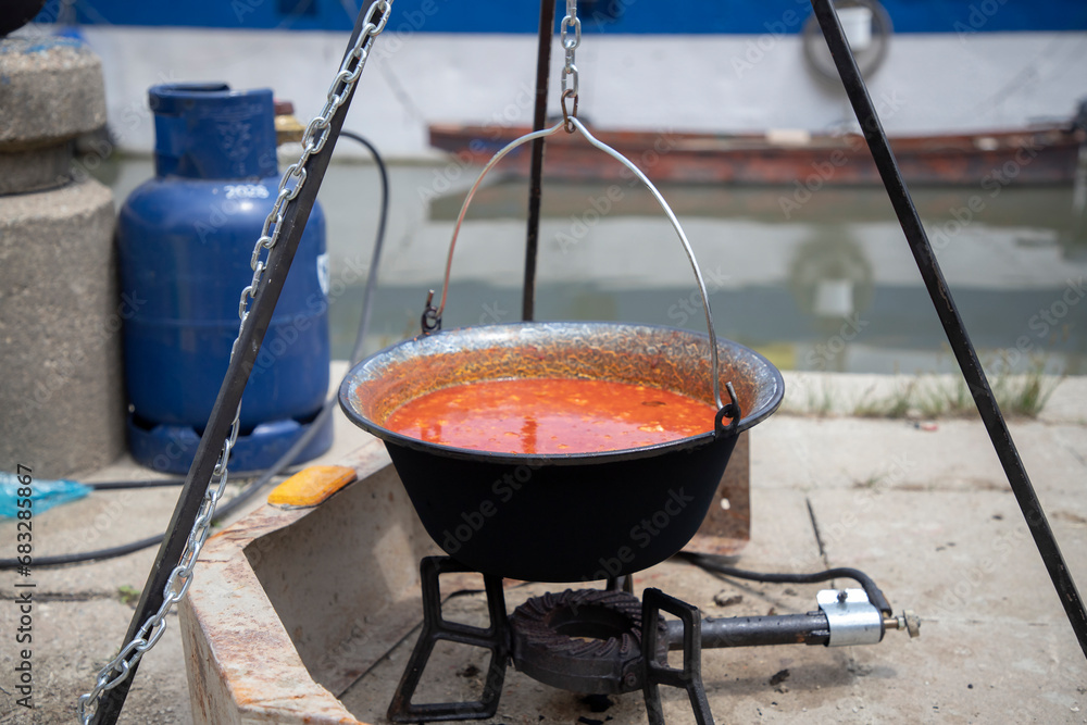 Fish soup just cooked in an outdoor fish pot on the riverbank Fish soup just cooked in an outdoor fish pot on the riverbank